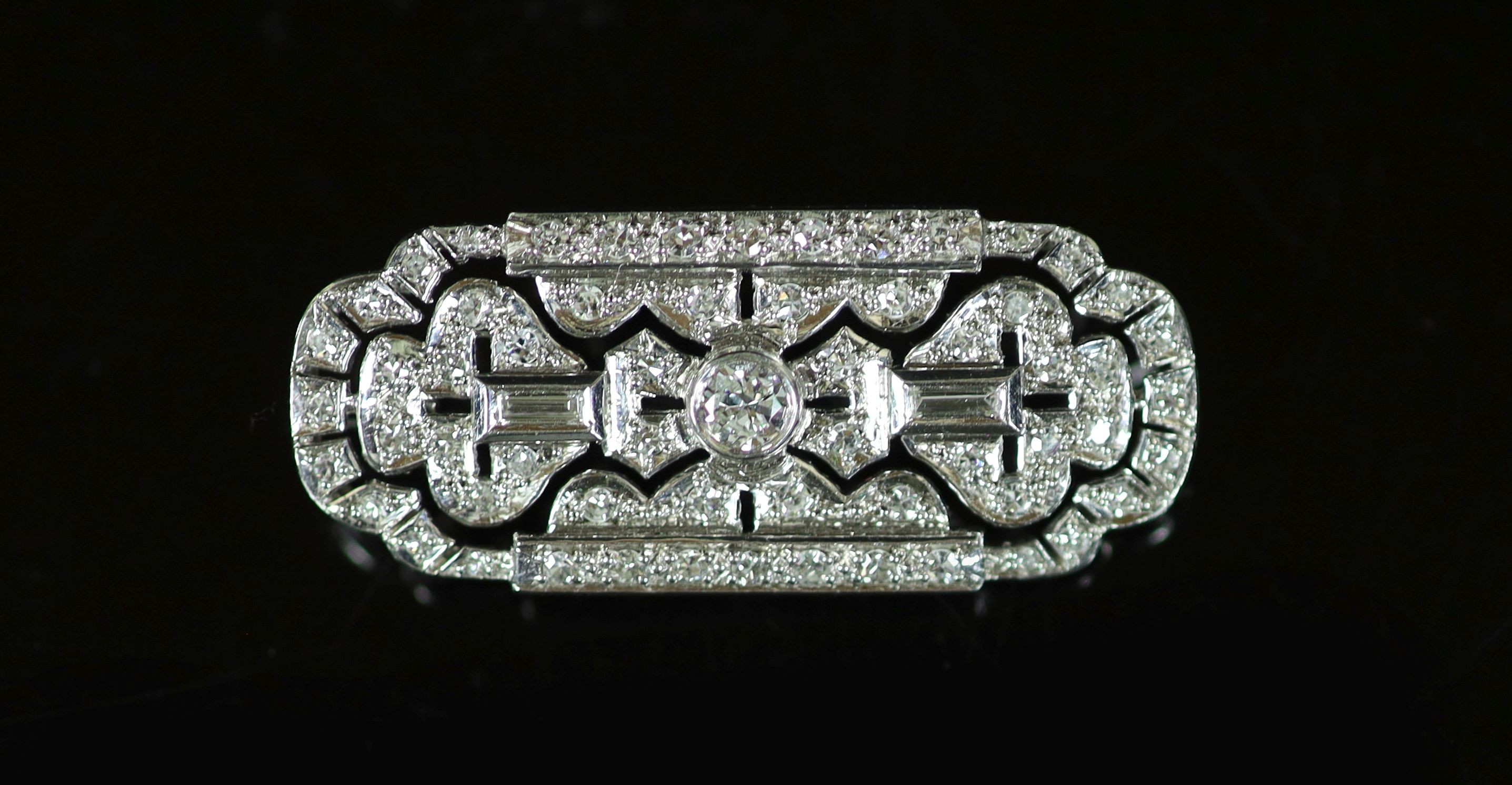 An Art Deco style pierced platinum, round and baguette cut diamond set shaped rectangular brooch